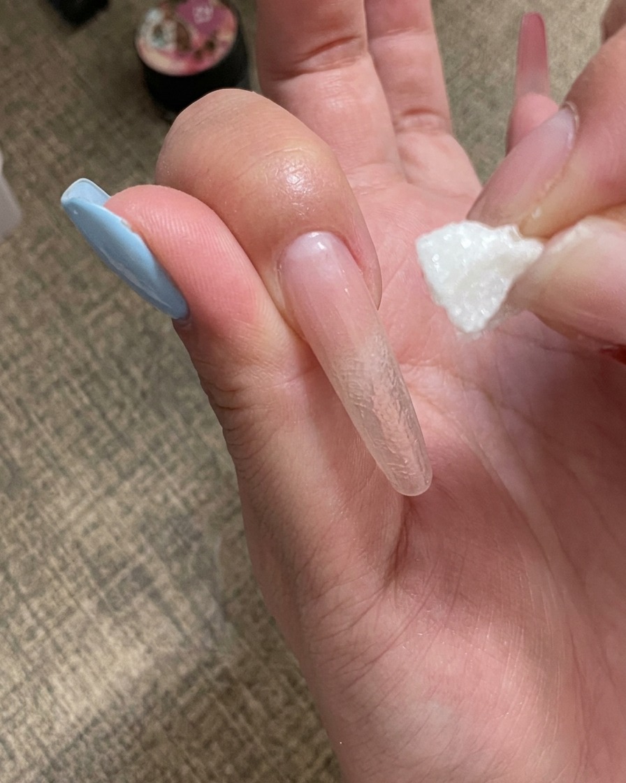 휴대용 미니 UV 램프 아래에서 큐어링 중인 손톱.