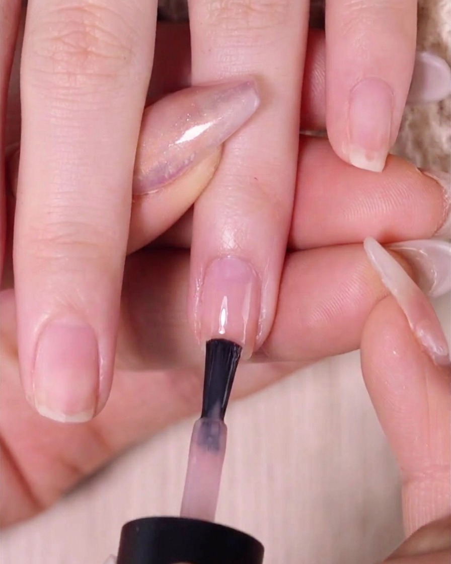 미리 블렌딩된 레이어 위, 손톱 상단 절반 정도에 두 번째 누드 핑크 폴리시를 바르는 브러시.