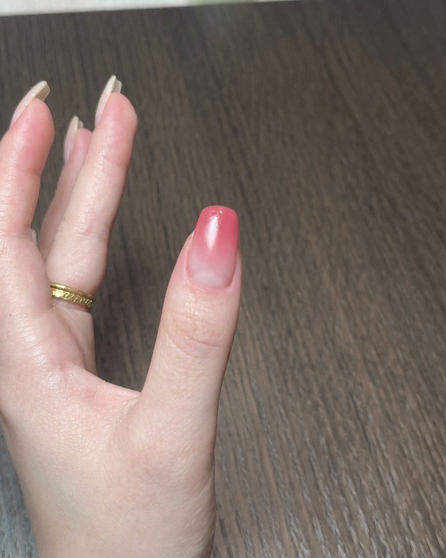 휴대용 미니 램프로 손톱의 젤 폴리시를 큐어링하는 모습.