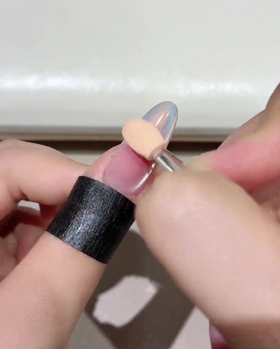 블러시 효과가 도포된 네일이 전문 UV/LED 램프 안에서 큐어링되는 모습.