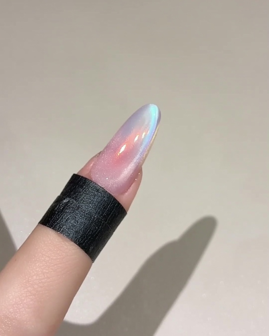 베이스 컬러가 발린 네일 위에 반짝이는 투명한 캣아이 젤을 브러시로 바르는 모습.