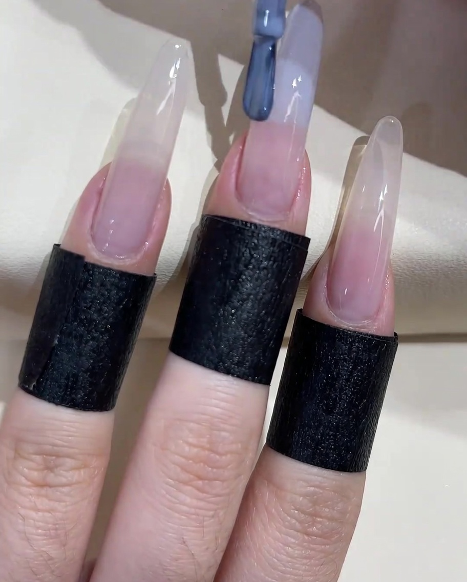 손톱의 앞쪽(프리 에지) 부분에 그레이 블루 젤 폴리시를 바르는 모습.
