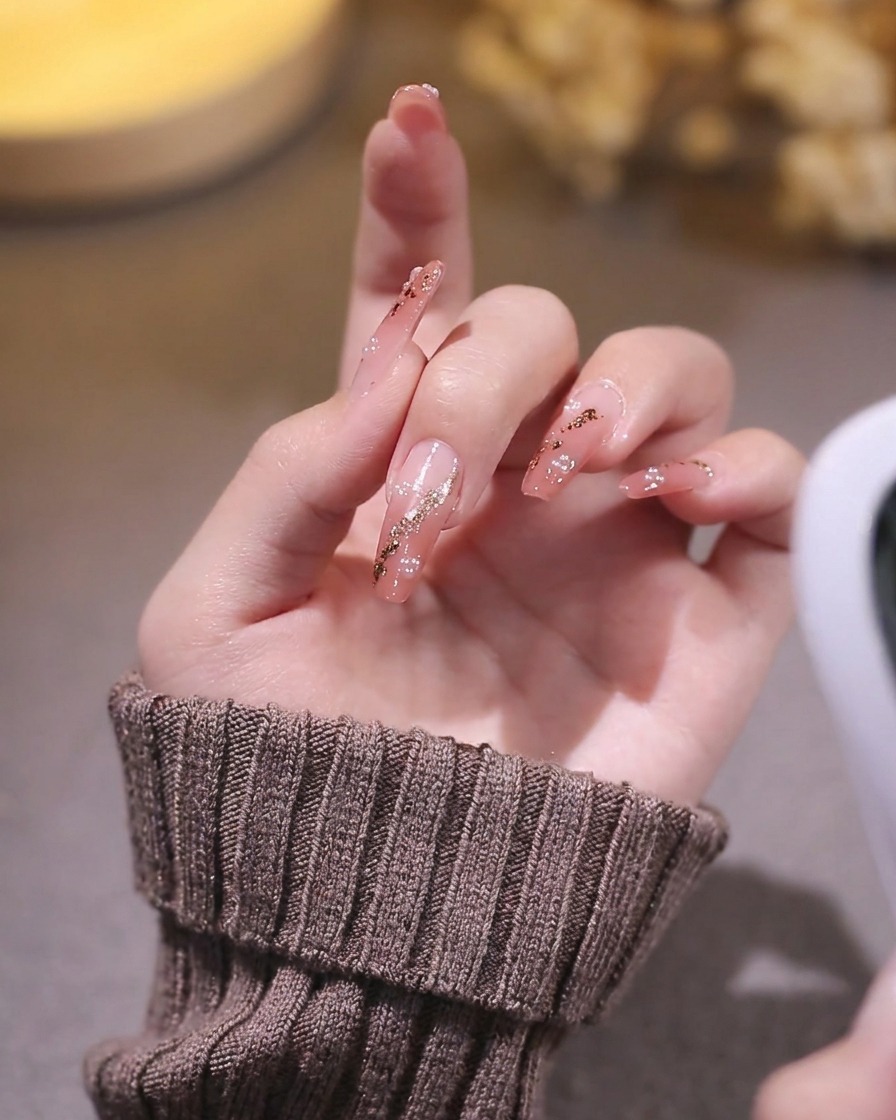 네일 램프의 불빛을 받으며 큐빅과 함께 경화 중인 네일 디자인 클로즈업.