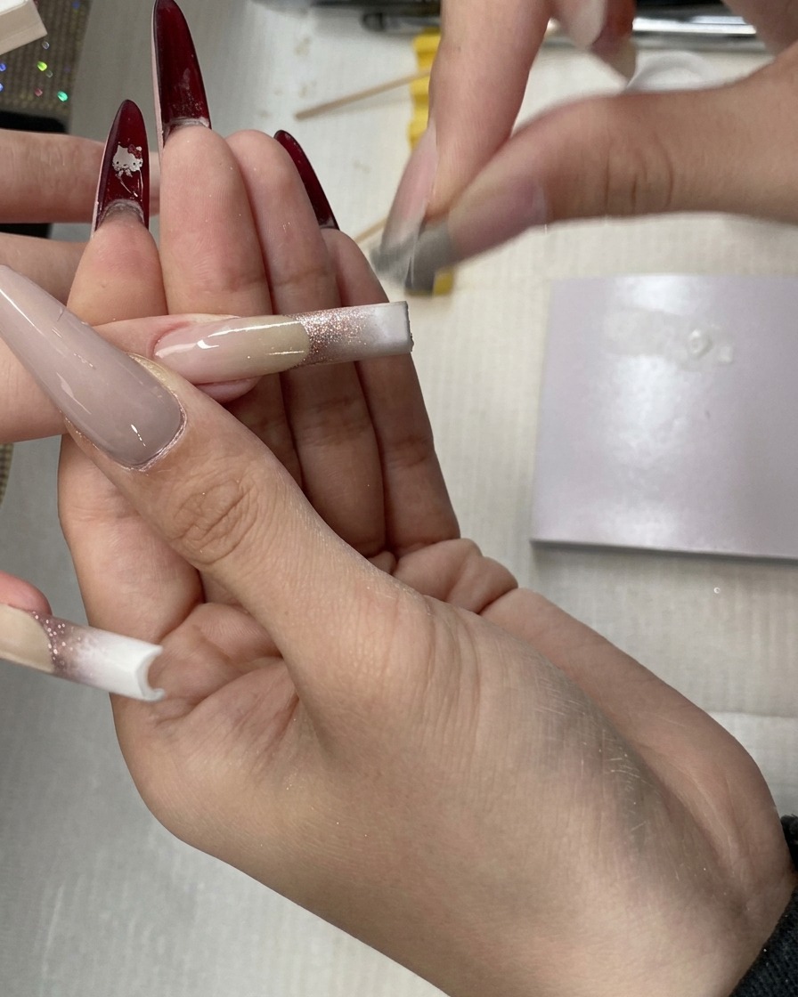 스펀지 툴로 네일에 화이트 젤을 위쪽으로 블렌딩하여 베이비부머 효과를 위한 부드러운 전환을 만드는 모습.