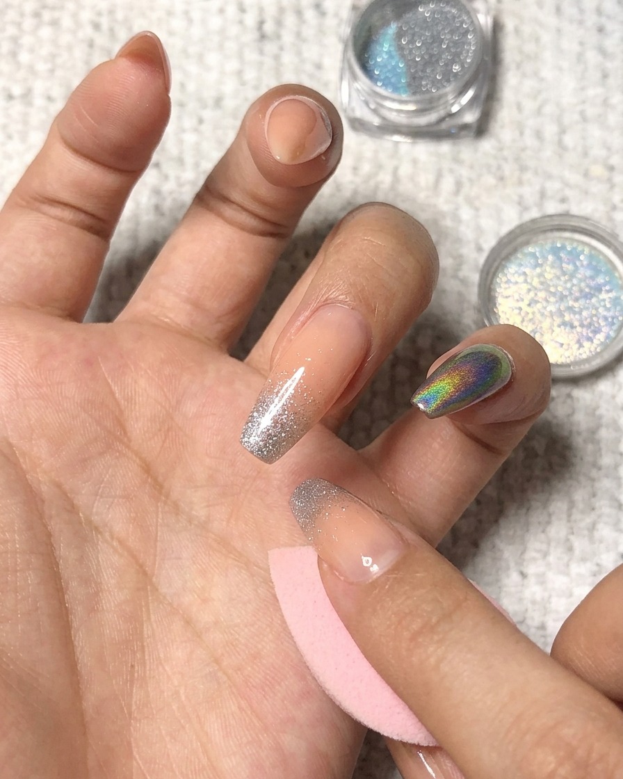약지 손톱 끝에 홀로그램 파우더를 톡톡 두드려 올리는 모습.