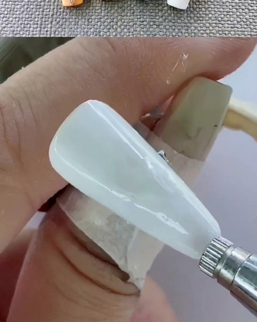 손가락을 UV 램프 안에 넣고 네일을 큐어링하는 근접 촬영 모습.