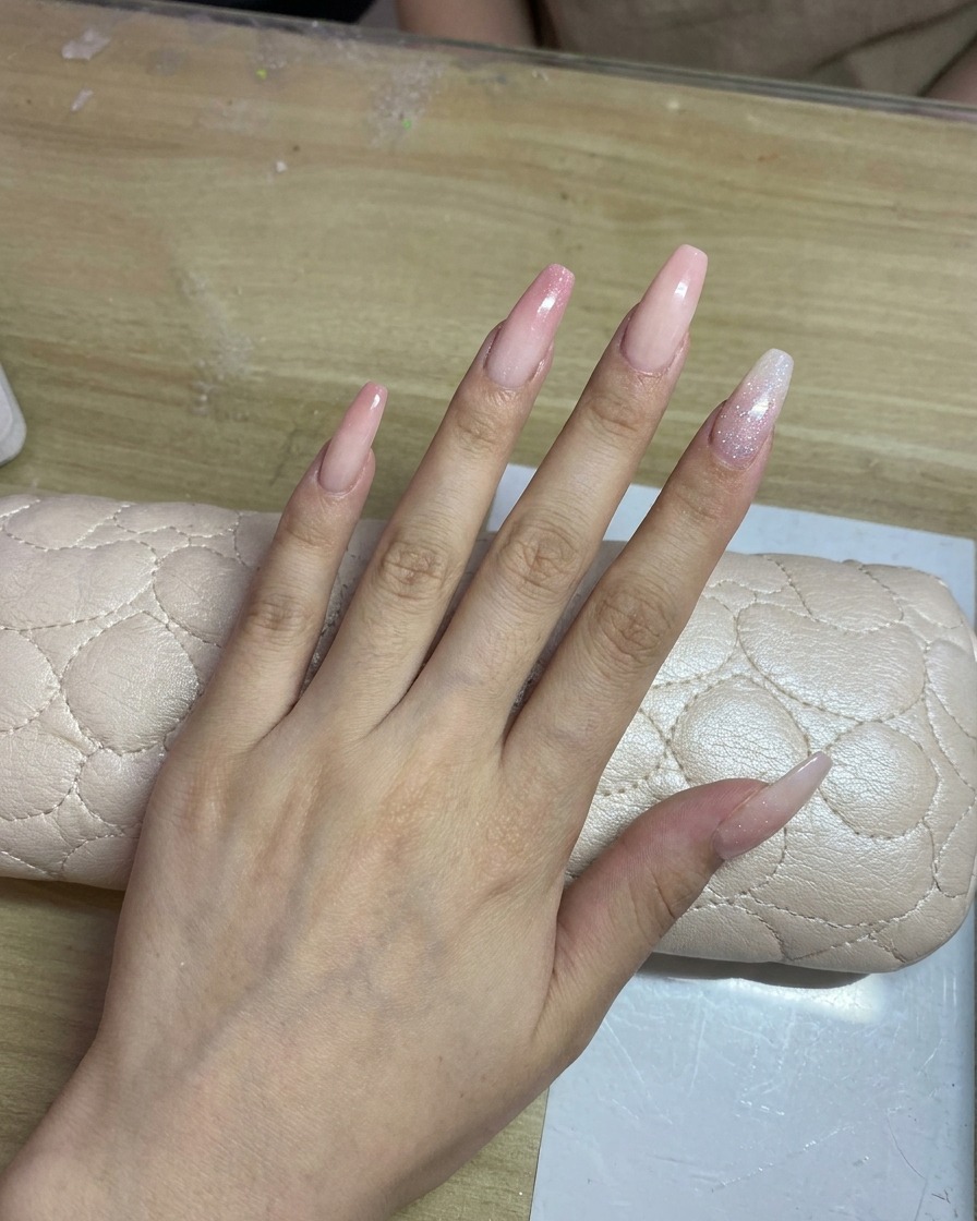 롱 네일 바디에 섬세한 핑크색 그라데이션을 에어브러시로 입히는 모습.