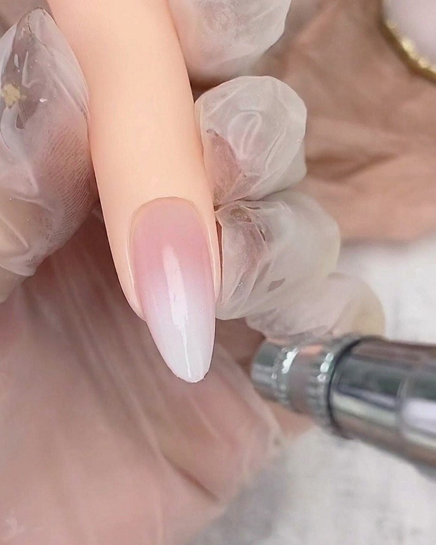 아몬드 쉐입 네일의 끝부분에 화이트 폴리시를 가볍게 분사하여 옴브레 그라데이션을 쌓아가는 모습.