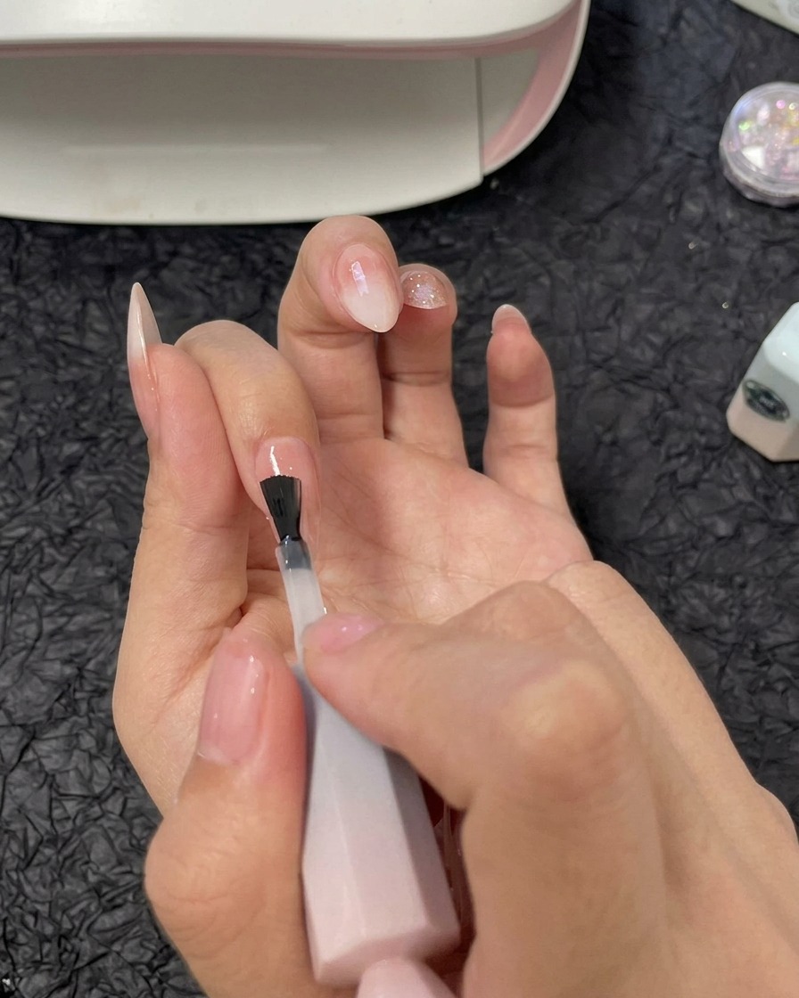 약지 손톱에 클리어 빌더 젤을 도포하는 모습