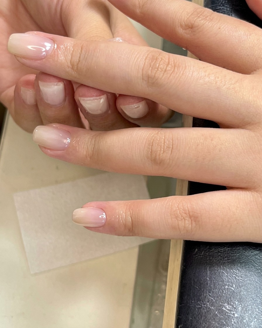 램프에서 큐어링을 마친 네일 표면의 미경화 젤을 보풀 없는 솜으로 깨끗하게 닦아내는 모습.