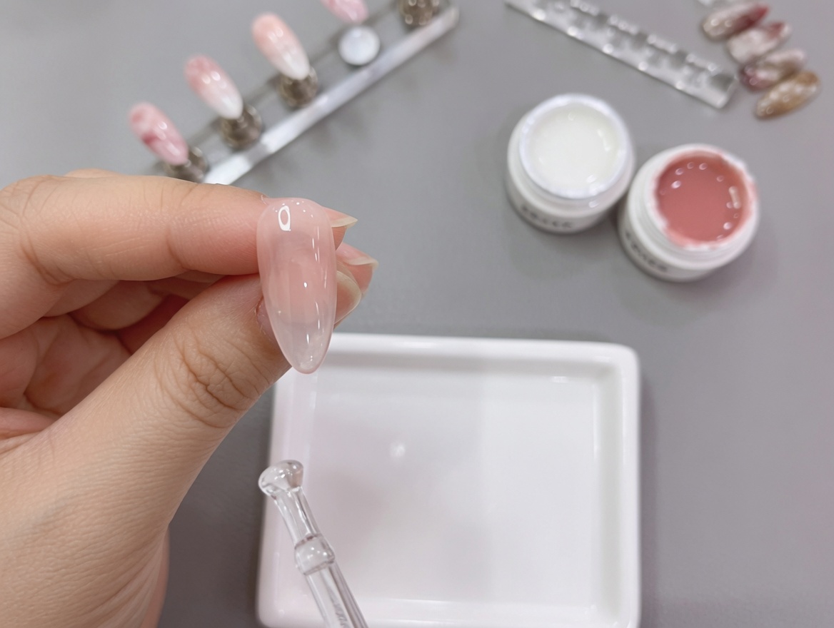 완성된 옴브레 네일을 최종적으로 UV 램프에 넣어 큐어링하는 손의 모습.