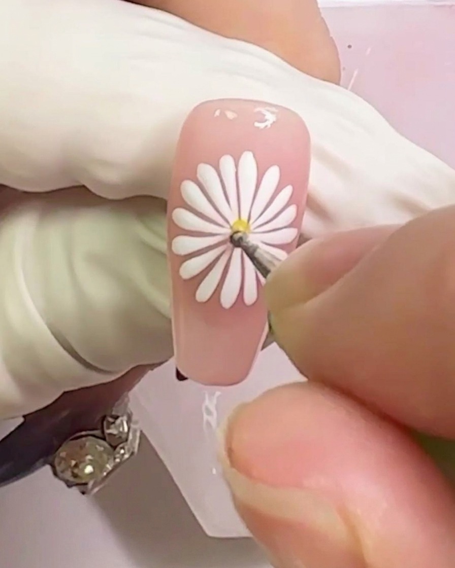 화이트 데이지 디자인의 중앙에 옐로우 젤 도트를 찍는 모습.