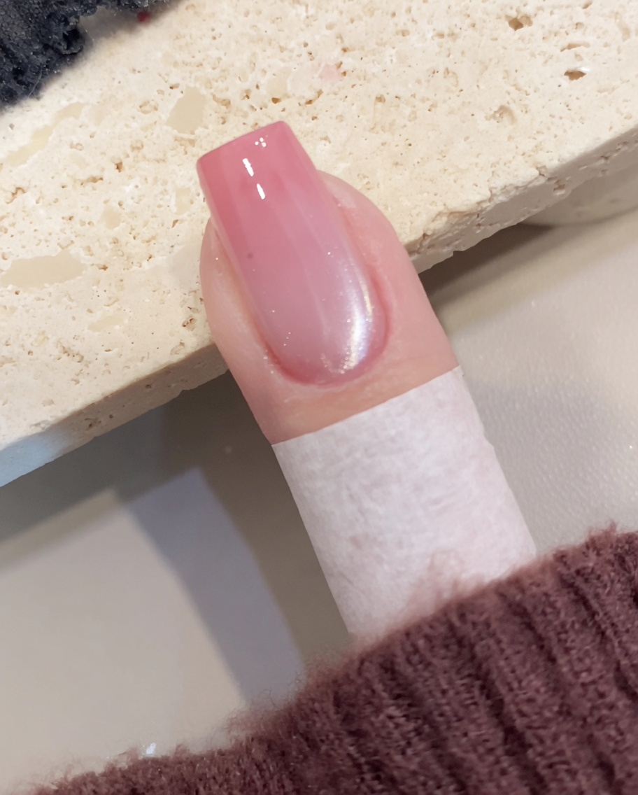 준비된 네일 위에 투명한 쉬머 자석 젤 폴리쉬를 브러시로 바르는 모습.