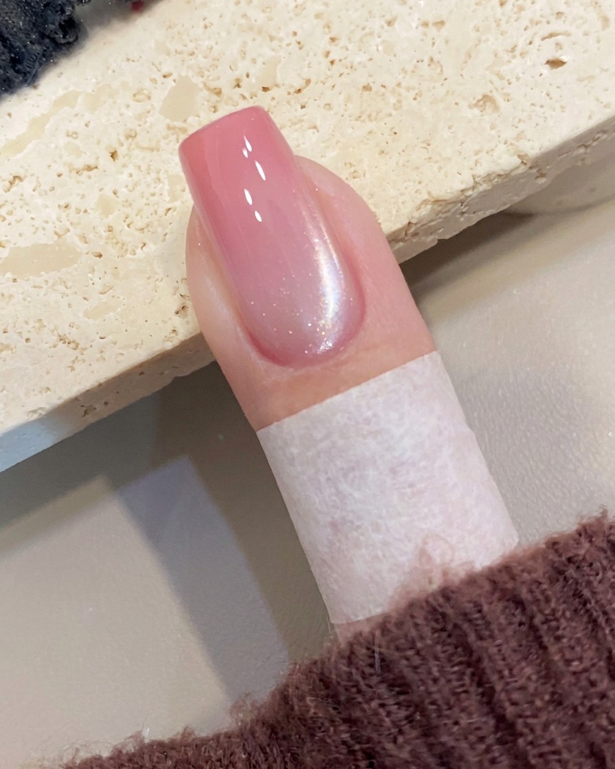 자석 도구를 네일 옆면에 대어 젖은 자석 젤 위에 사선 쉬머 라인을 만드는 모습.