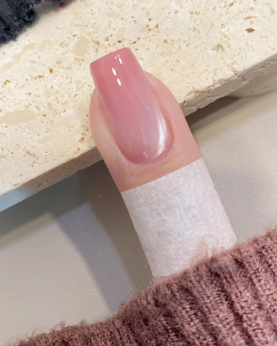 브러시를 사용하여 네일 끝부분에 피치 컬러 젤을 소량 올리는 모습.