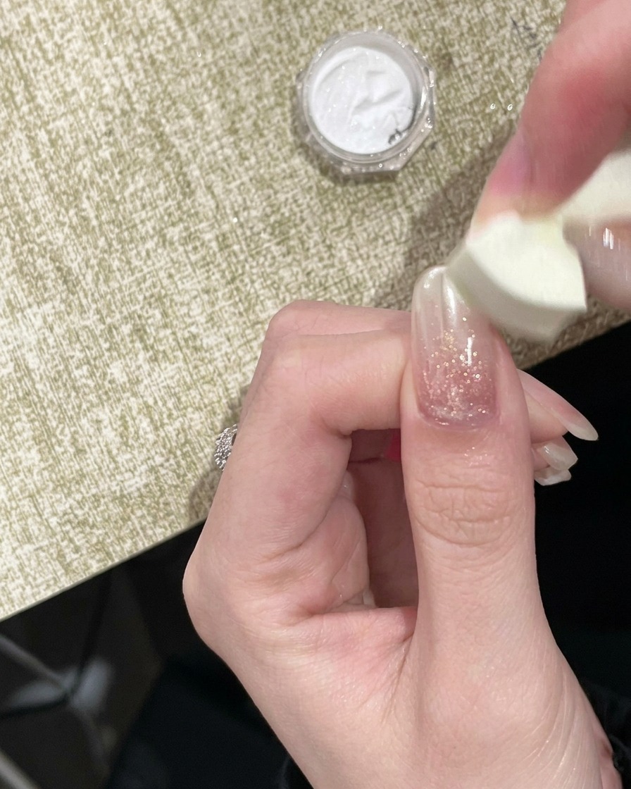 스펀지 어플리케이터로 손톱 끝에 골드 크롬 파우더를 톡톡 두드리는 모습.
