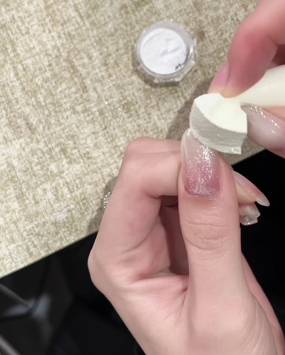 골드 크롬이 팁에 장식된 네일 위에 최종 광택 탑코트를 바르는 브러시.