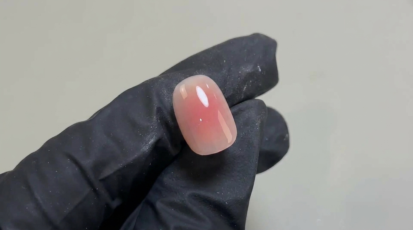 짧고 둥근 손톱 위에 부드러운 핑크빛 그라데이션과 고광택 마무리가 돋보이는 섬세하고 자연스러운 블러셔 젤 네일 디자인입니다.