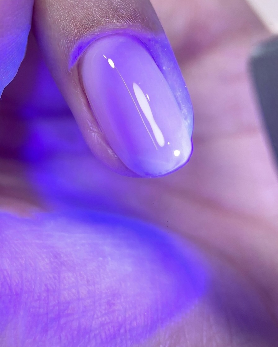 핑크색 젤이 발린 손톱을 UV/LED 램프에 넣어 큐어링하는 모습.