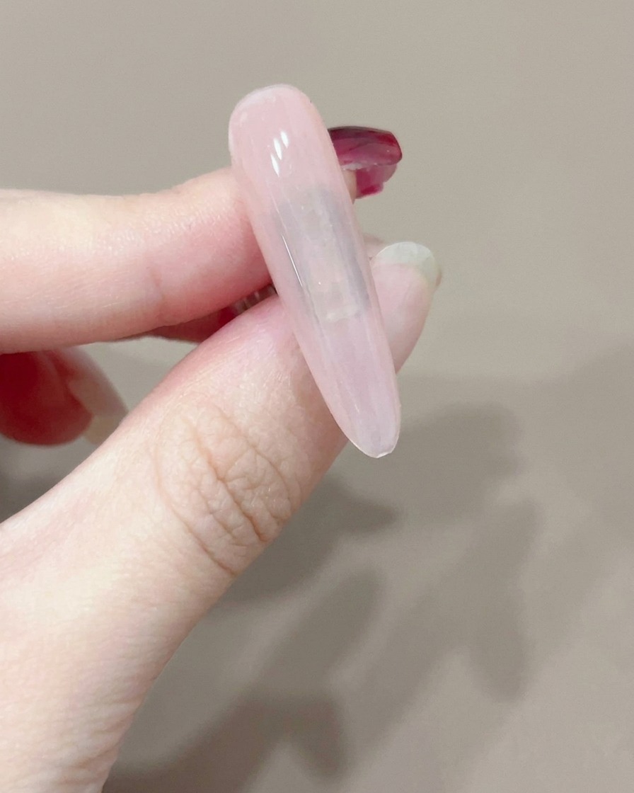 작은 휴대용 UV 램프 아래에서 큐어링되고 있는 단일 네일.