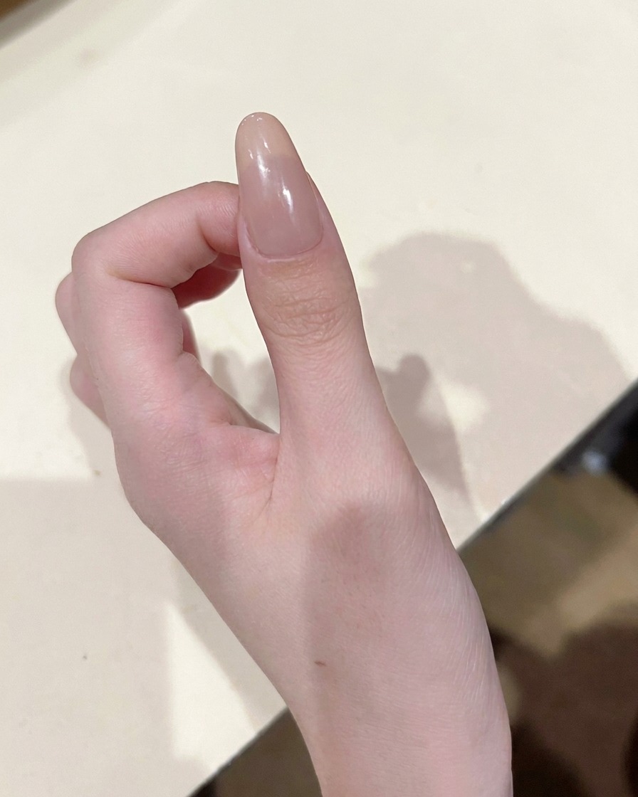 세밀한 브러쉬로 누드 네일 중앙에 핑크 컬러 젤을 작고 정확하게 찍어 바르는 모습.