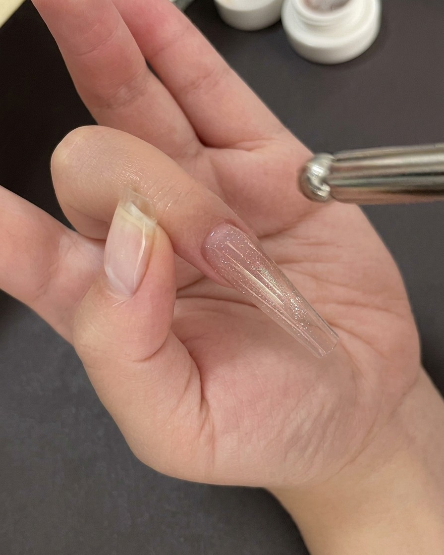 자외선/LED 램프 아래에서 젤 베이스를 큐어링하고 있는 모습.