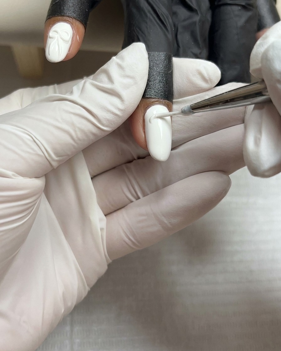 화이트 젤이 발린 손톱 중앙에 꾸덕한 화이트 스컬프팅 젤 한 방울이 놓인 모습.