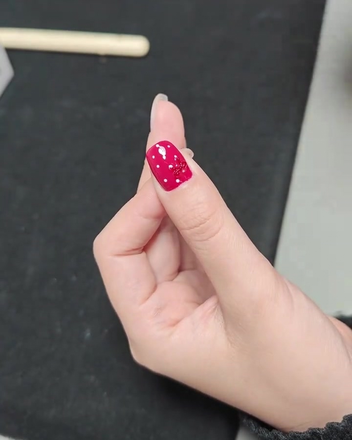 완성된 레드 도트 리본 네일을 UV 램프 안에서 마지막으로 큐어링하는 모습.
