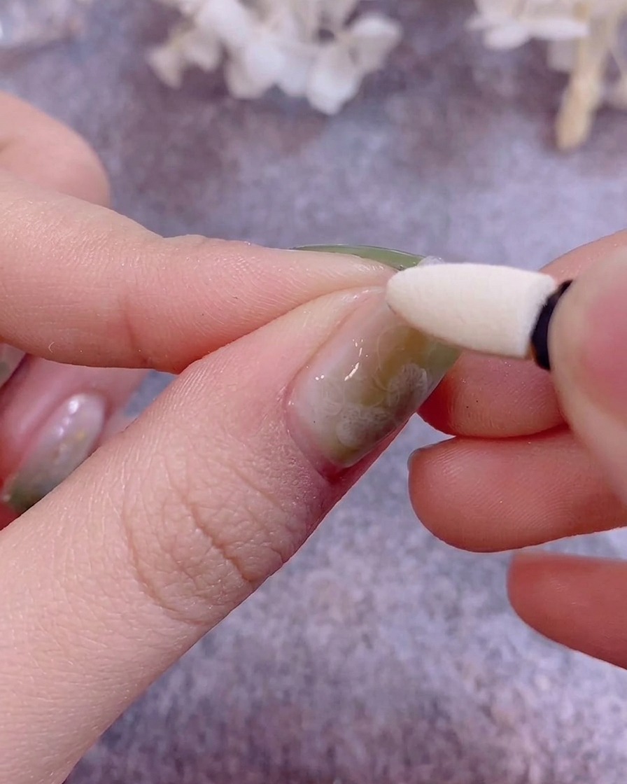 실리콘 아이섀도우 팁으로 메탈릭 크롬 파우더를 젤 네일 위에 문지르는 모습.