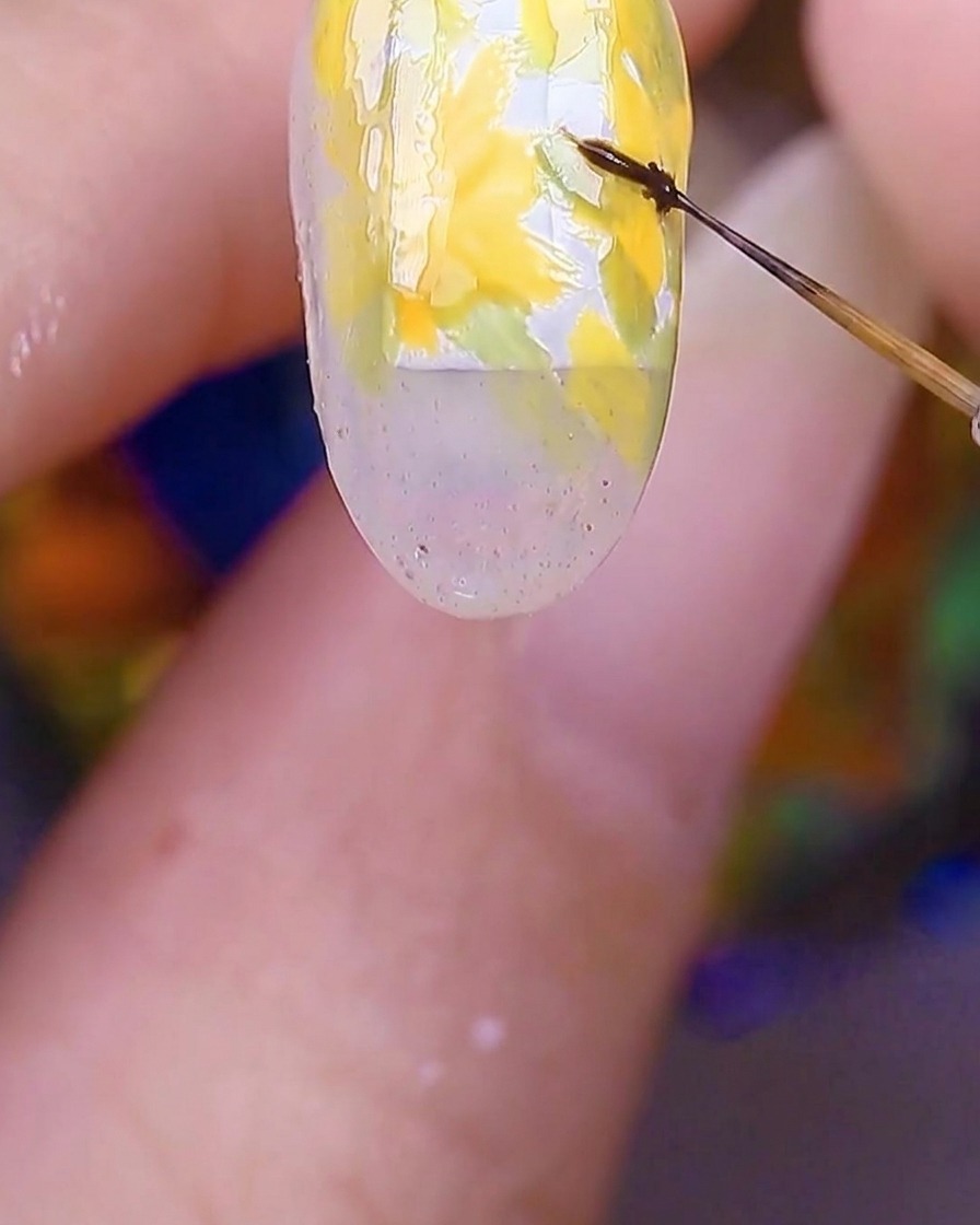 노란색 꽃잎 중앙에 세필 브러시로 진한 갈색 점을 찍는 모습.