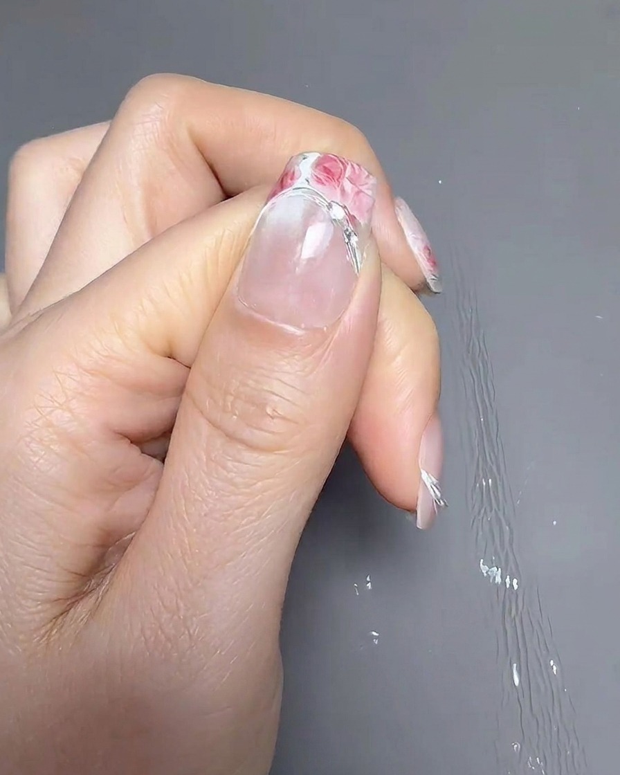 핀셋을 사용하여 일반적인 프렌치 위치보다 조금 더 높게 프렌치 가이드 스티커를 붙이는 모습.