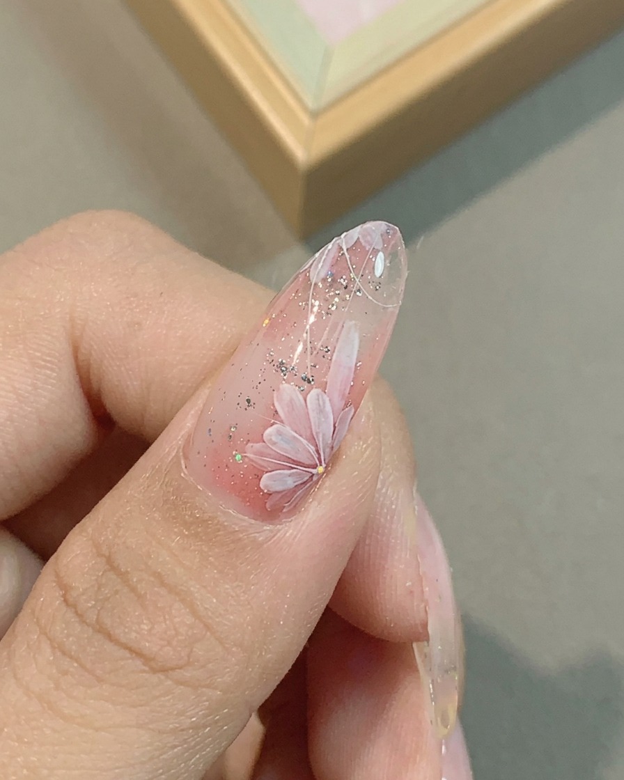 세필 붓으로 핑크 데이지 꽃잎의 디테일을 다듬는 모습.