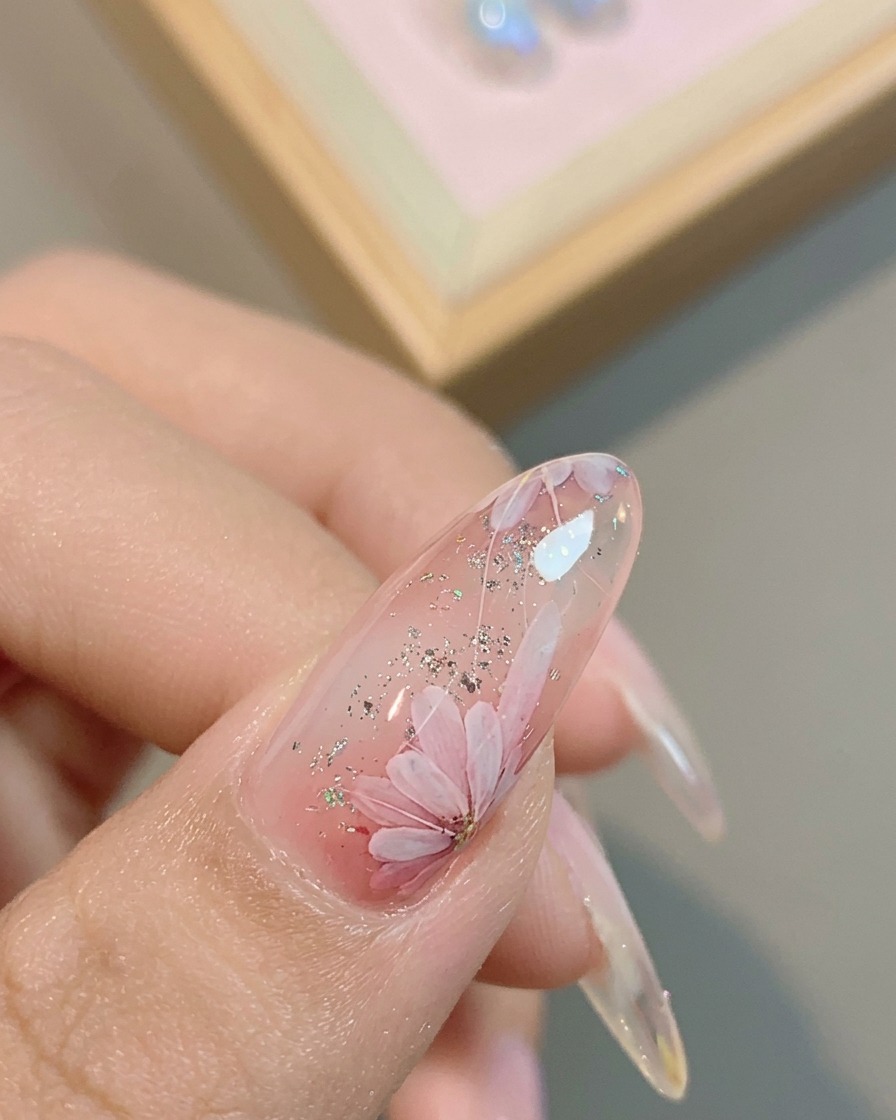 완성된 데이지 디자인 위에 마지막 광택 탑 코트를 바르는 모습.