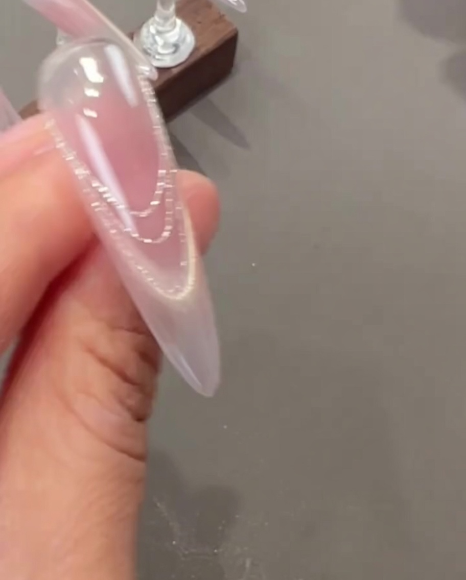 핀셋으로 작은 압화와 진주 파츠를 네일 위에 올리는 모습.