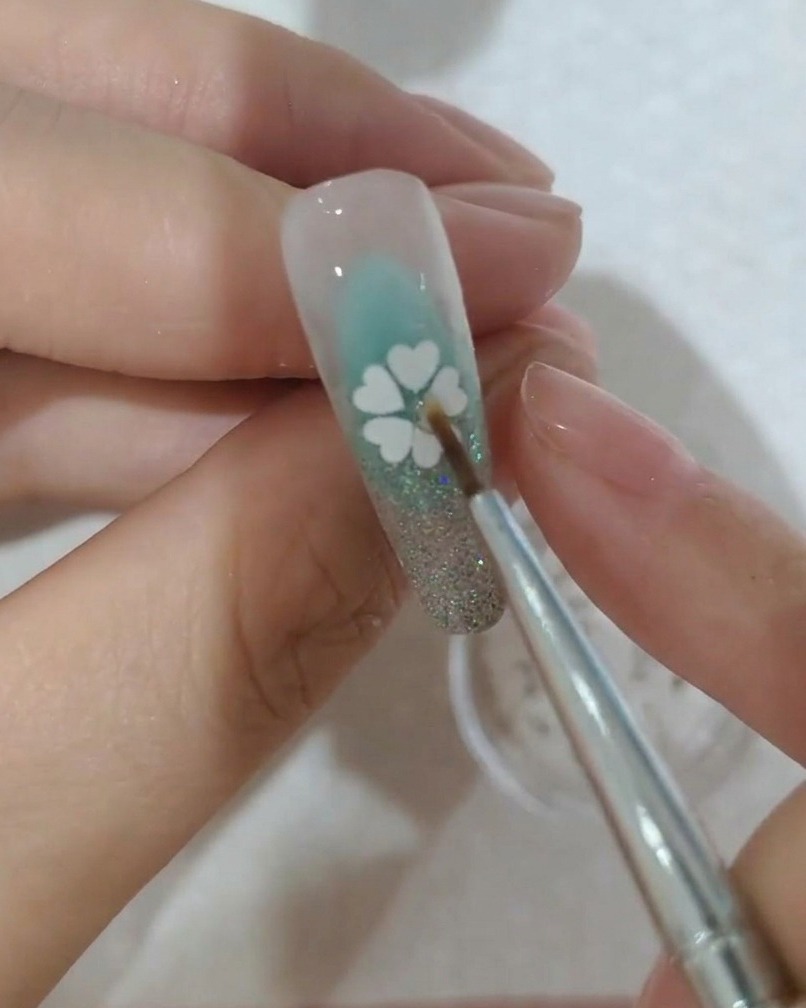 꽃 중앙 접착제 위에 작은 크리스털을 올리는 모습.