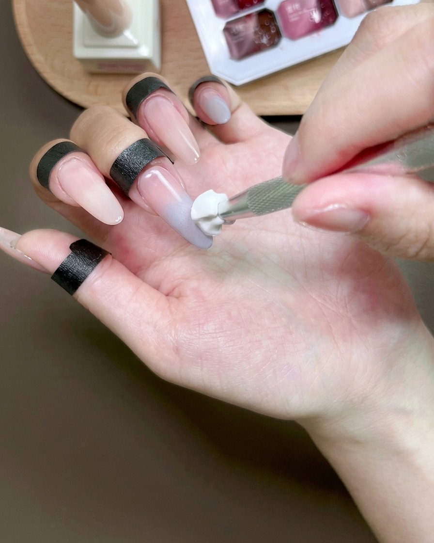 스펀지 툴로 손톱 위의 블루 젤을 블렌딩하여 옴브레 효과를 만드는 모습.