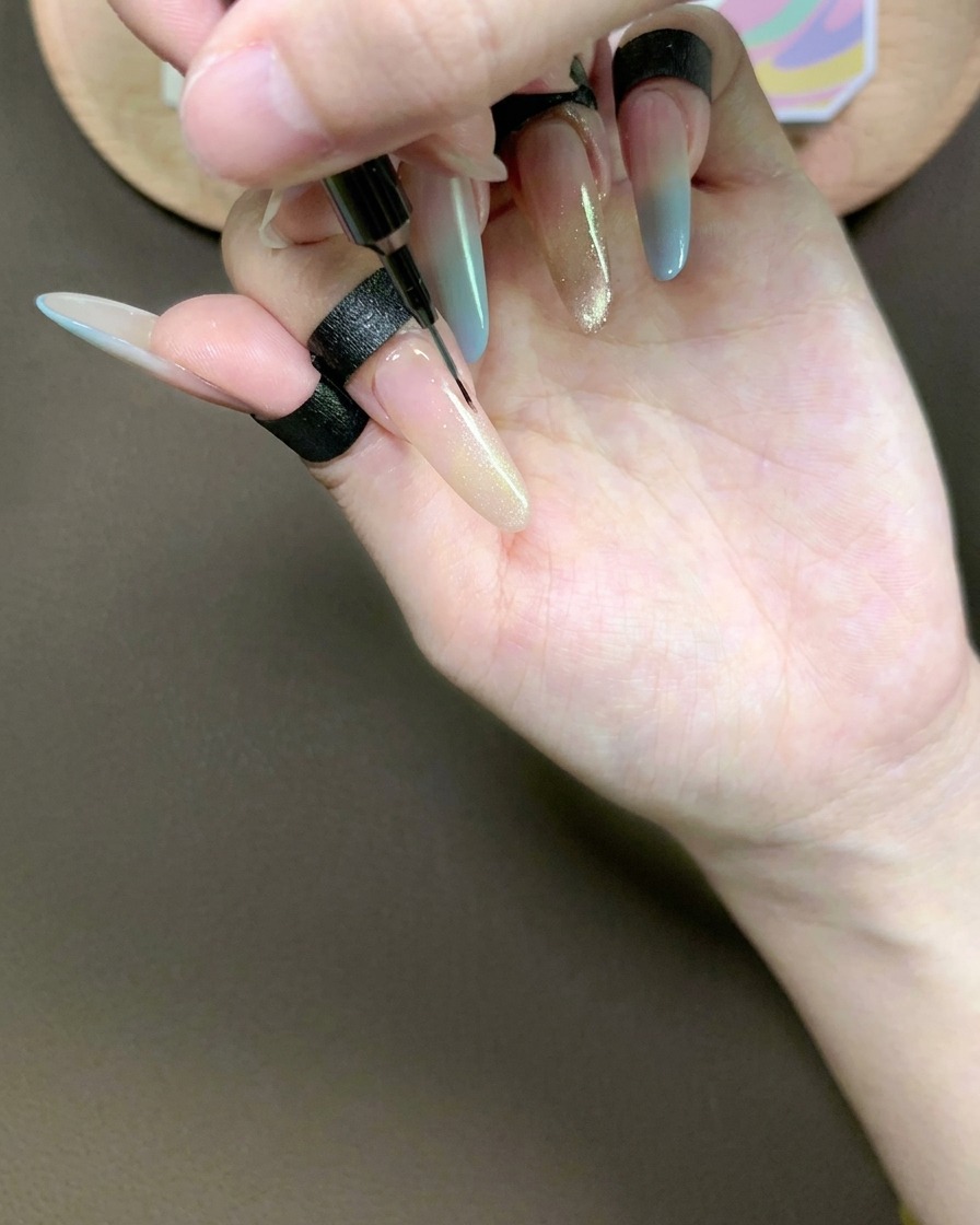 라인 브러시로 검지의 캣아이 젤을 블렌딩하여 자연스럽게 연결하는 모습.