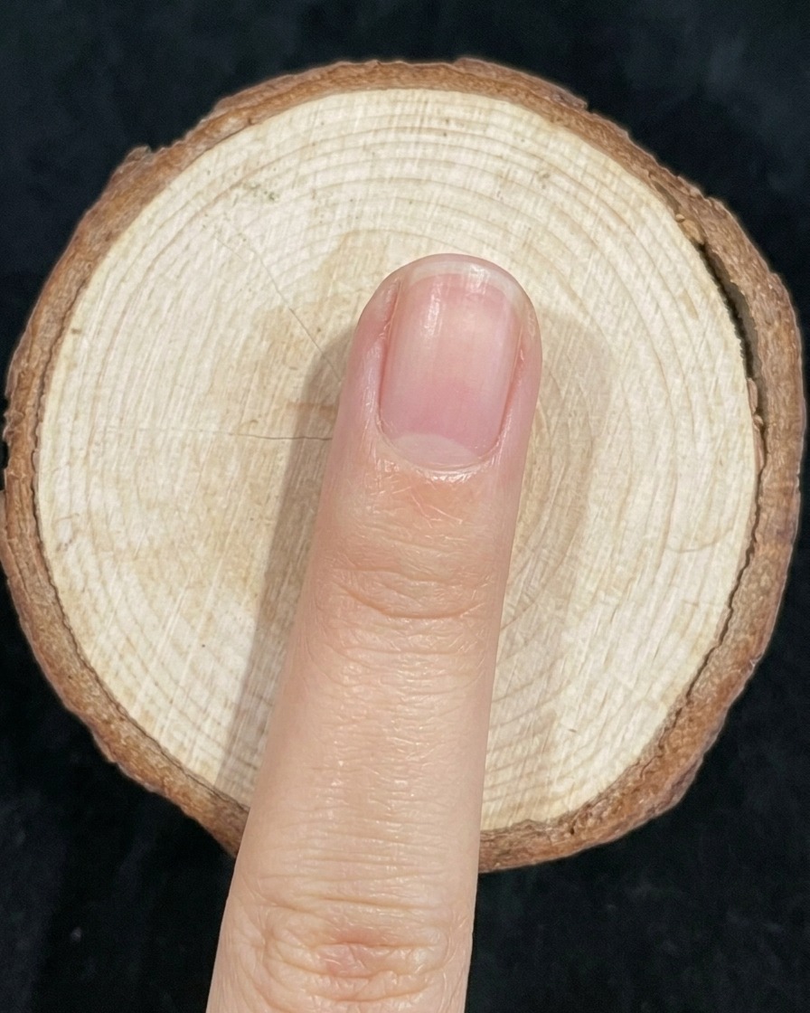 네일 브러시로 손톱의 그린과 블루가 만나는 경계선을 가볍게 블렌딩하는 모습.