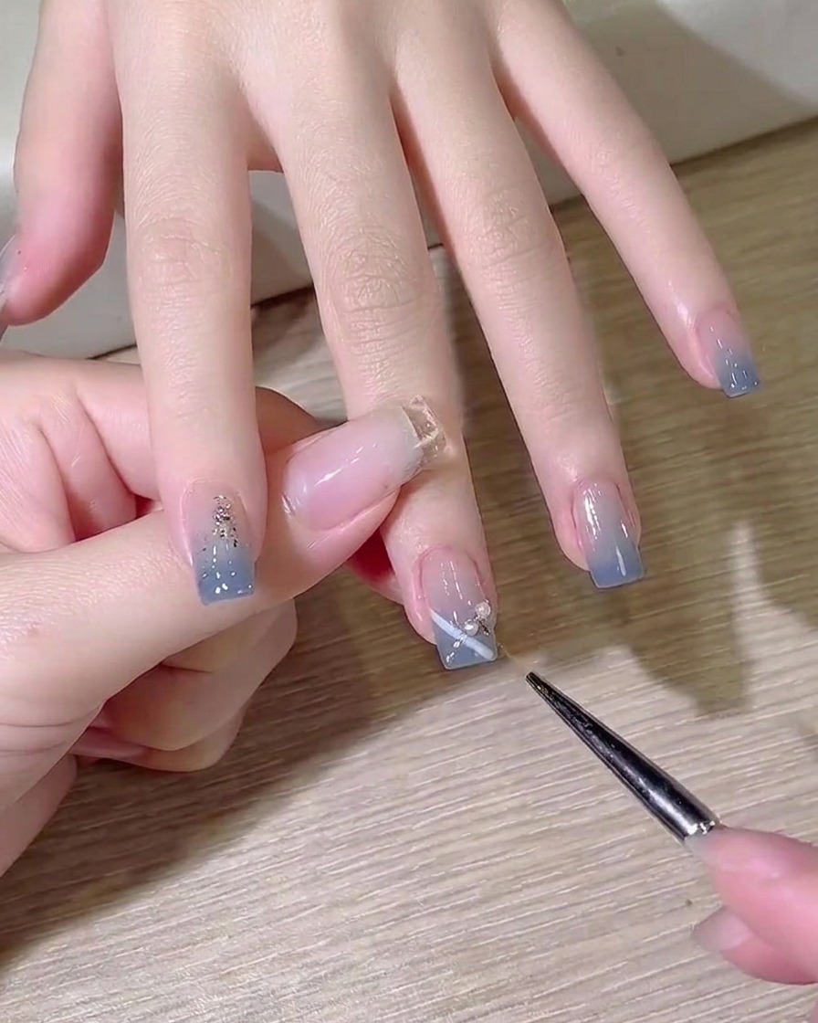 디테일 브러시로 손톱 표면에 접착제용 투명 빌더 젤을 작은 방울만큼 덜어내는 모습.