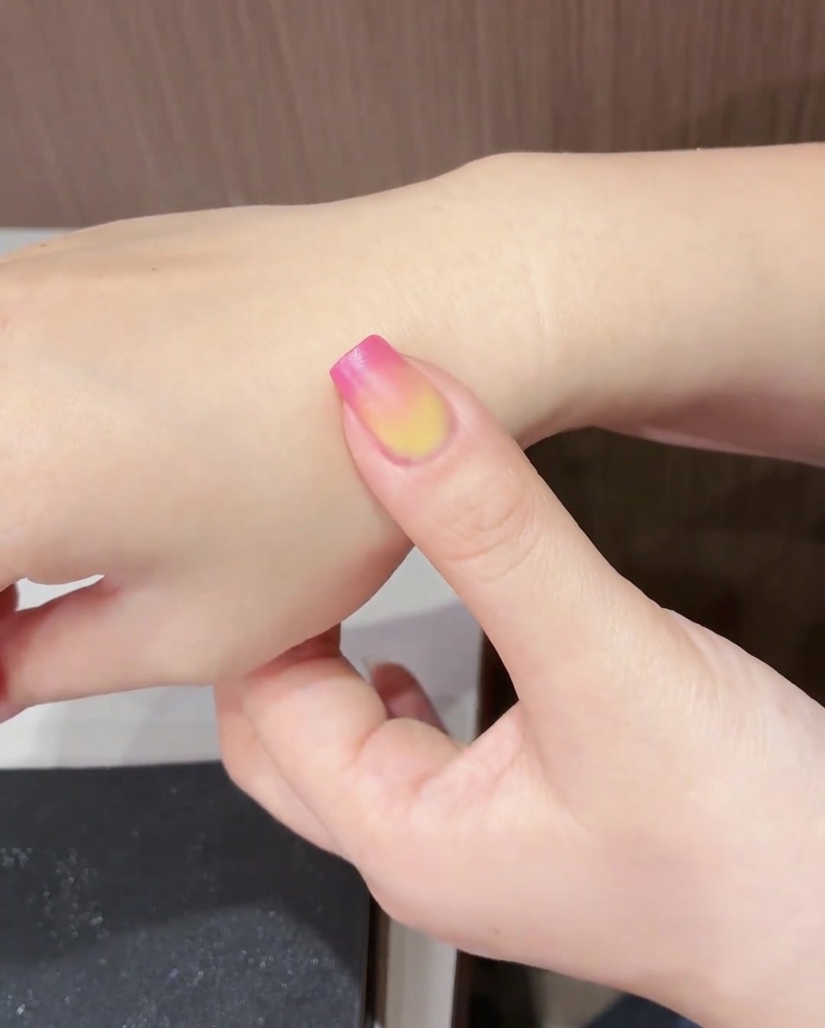 완성된 튤립 아트가 올려진 손톱을 UV/LED 램프에 넣어 굽는 모습.