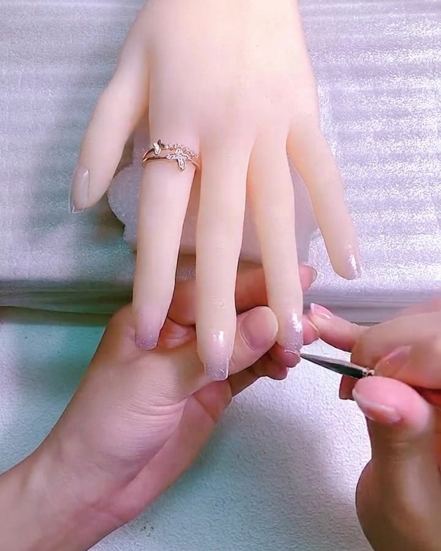 손톱에 크기가 다른 두 개의 데이지 꽃이 그려진 모습.