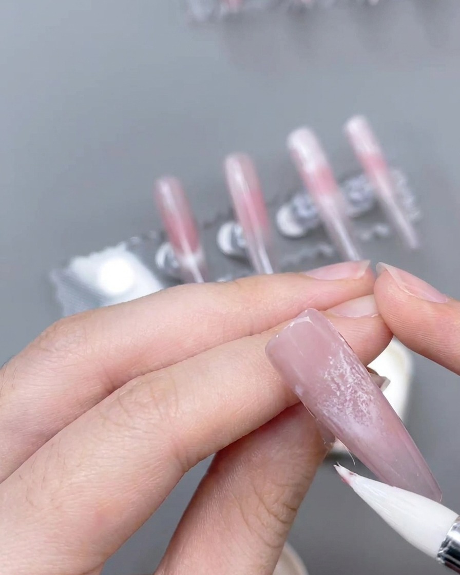 세필 브러시로 레이스 위에 핑크색 포인트 라인을 그리는 모습.