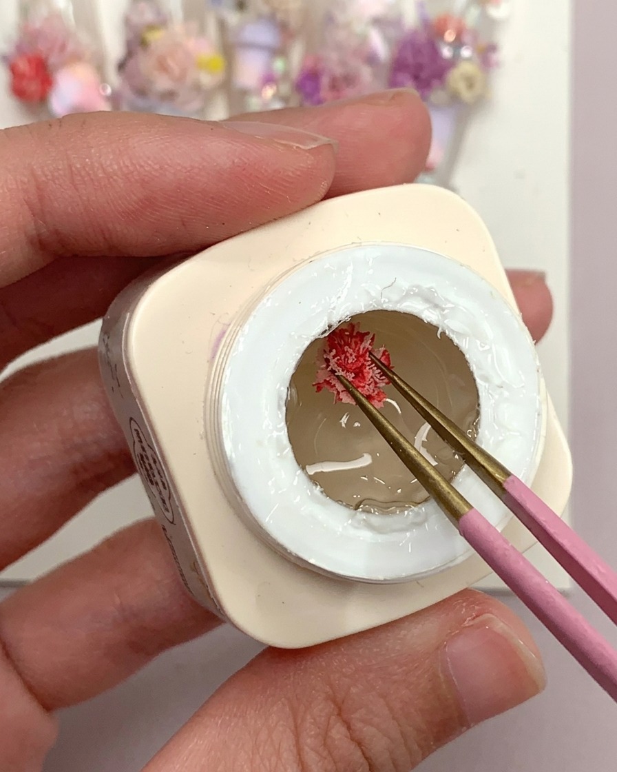 브러시로 투명 네일 팁 위에 프로스티드 젤 글루를 떨어뜨리는 모습.