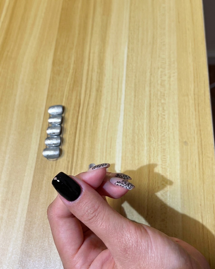 자연 손톱에 블랙 젤 폴리시를 얇고 고르게 펴 바르는 모습.