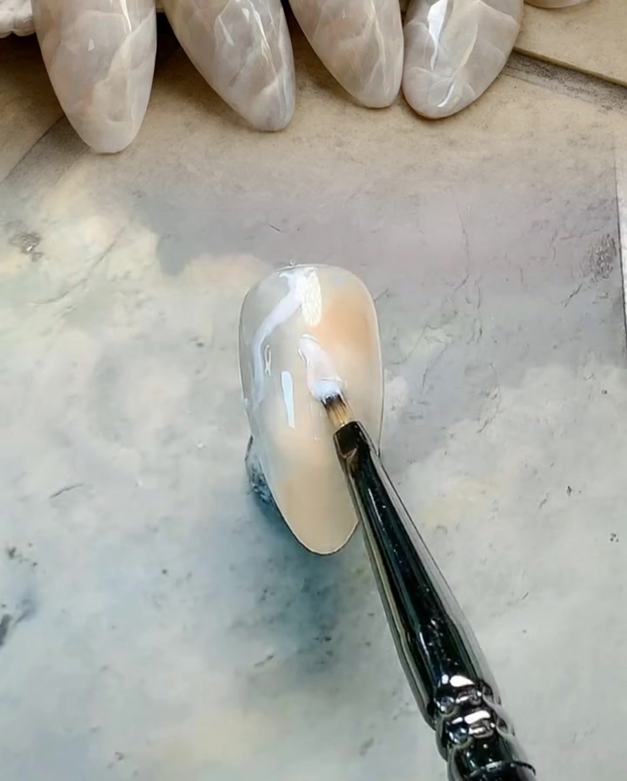 납작한 붓으로 브라운과 그레이 젤을 부드럽게 섞는 모습.
