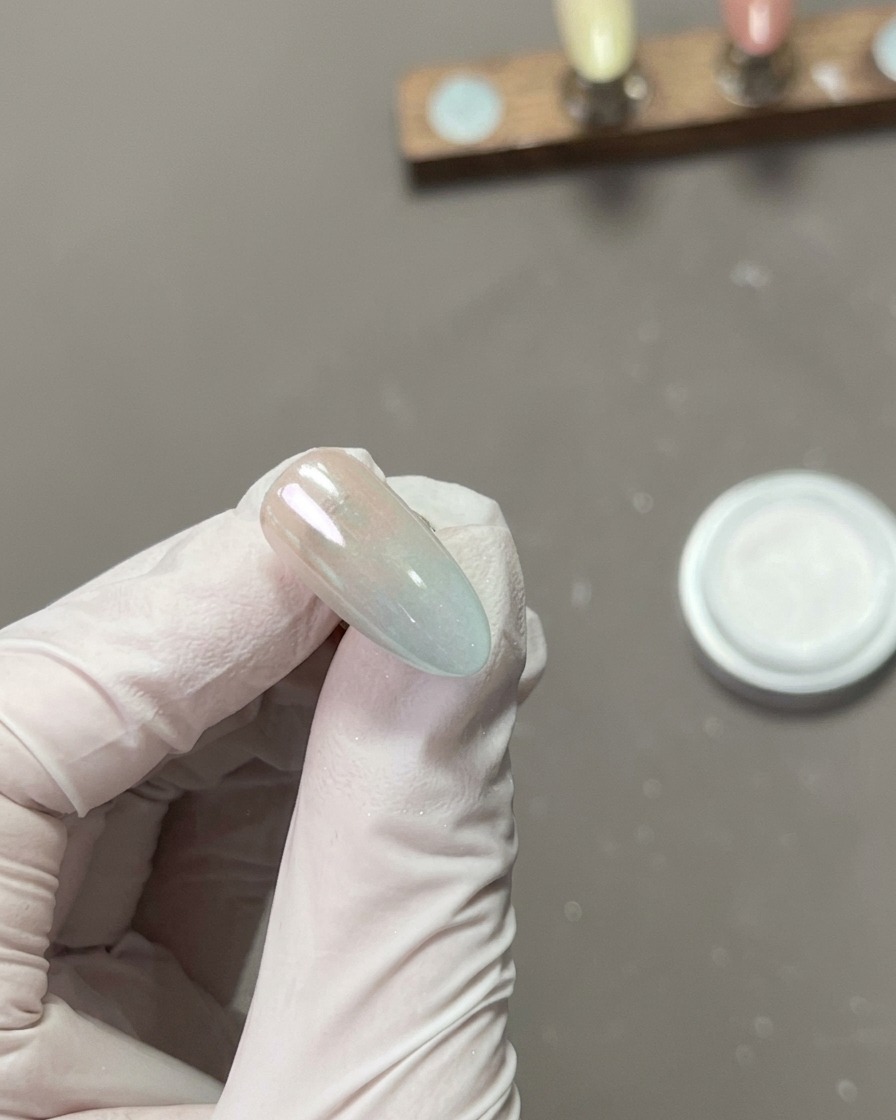 크롬 파우더가 묻은 네일 표면을 깨끗한 손가락으로 문질러 거울처럼 반짝이게 만드는 모습.