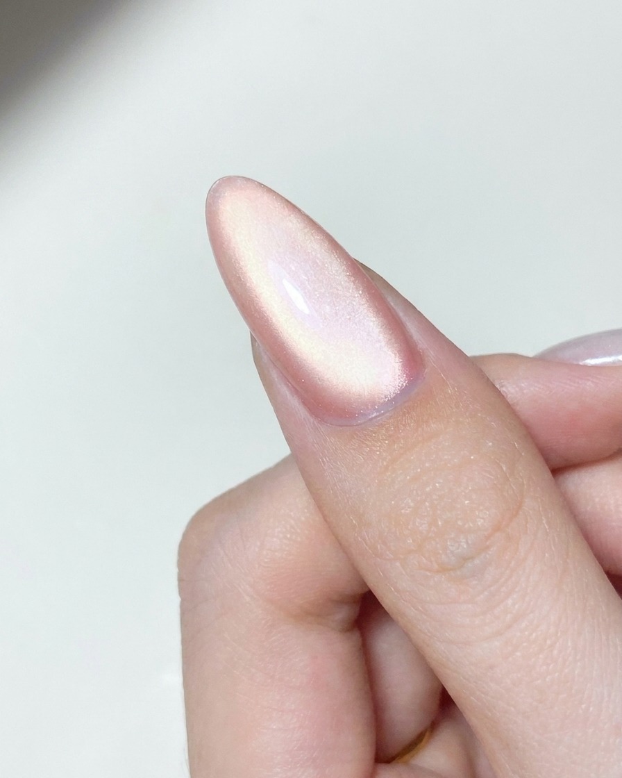 큐어링된 젤 네일 표면에 스폰지 팁 어플리케이터로 오로라 크롬 파우더를 문지르는 모습.