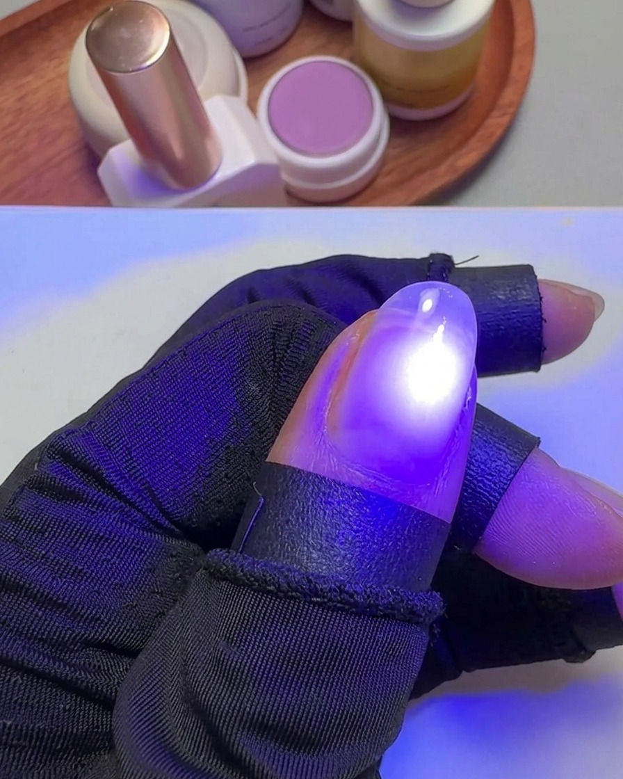 엄지손톱을 휴대용 UV 램프에 넣어 젤을 경화하는 모습.