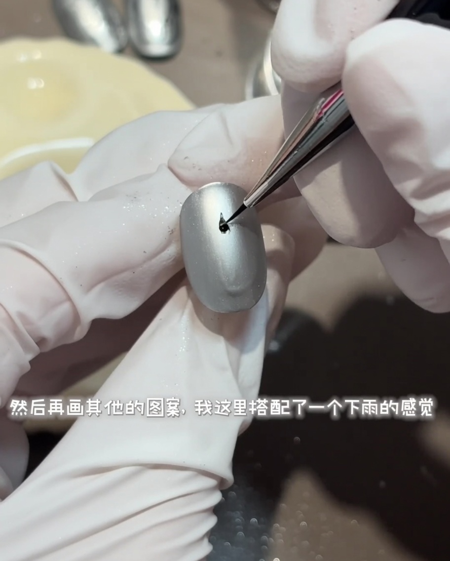 매트한 회색 네일 위에 라이너 브러시로 섬세한 원형 물결 디자인을 광택 탑코트로 그리는 모습.