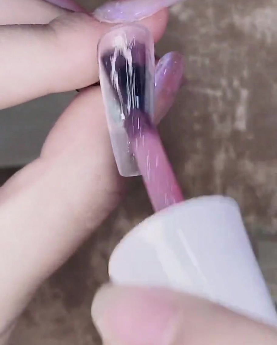첫 번째로 큐어링된 젤 위에 반투명한 핑크 젤을 두 번째로 바르는 브러시.